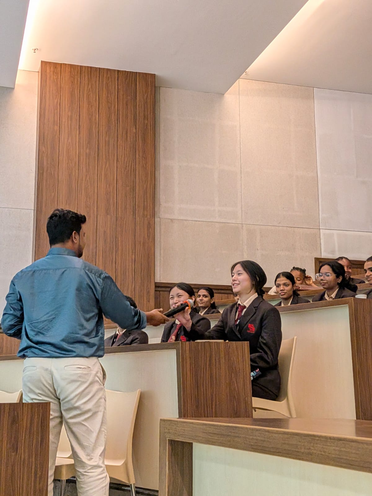 Facilitator handing the microphone to a nursing student